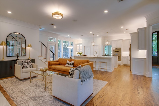 1360 Bent Trail Cir, Southlake, TX 76092 - living room featuring healthy amount of natural light, light wood-style flooring, stairway, crown molding, and recessed lighting