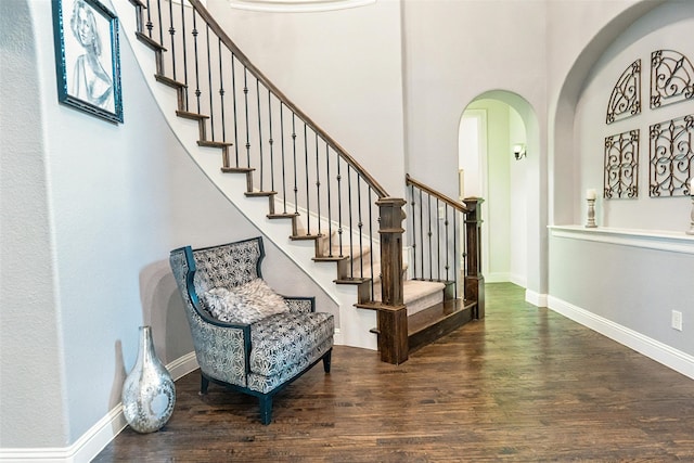 8051 Harliquin Ct, Frisco, TX 75035 - foyer featuring arched walkways, wood finished floors, stairs, and baseboards