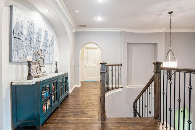 8051 Harliquin Ct, Frisco, TX 75035 - hall featuring crown molding, dark wood finished floors, an upstairs landing, arched walkways, and recessed lighting