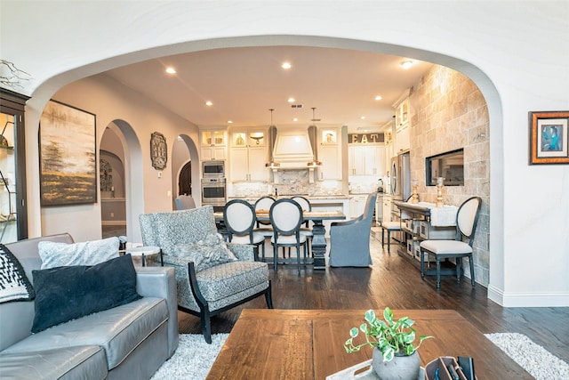 8051 Harliquin Ct, Frisco, TX 75035 - living room featuring dark wood-style floors, arched walkways, baseboards, and recessed lighting