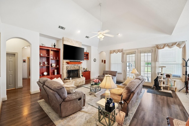 2109 County Road 4522, Justin, TX 76247 - living room with lofted ceiling, arched walkways, a stone fireplace, a ceiling fan, and wood finished floors