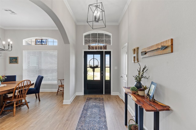 386 Frederick Dr, Robinson, TX 76706 - entryway featuring a chandelier, crown molding, arched walkways, light wood finished floors, and baseboards