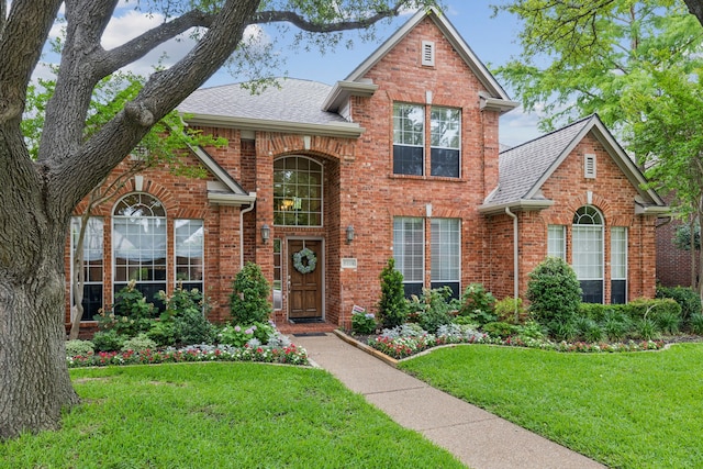 6305 Glenhollow Dr, Plano, TX 75093 - traditional-style home with brick siding, a front lawn, and a shingled roof