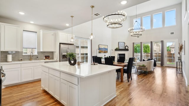 15270 Catalpa Rd, Frisco, TX 75035 - kitchen featuring stainless steel refrigerator with ice dispenser, a sink, white cabinets, light countertops, and recessed lighting