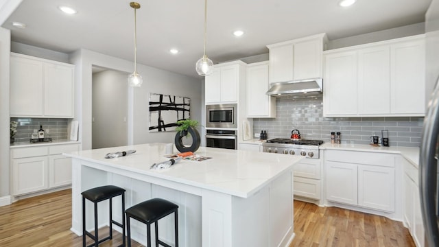15270 Catalpa Rd, Frisco, TX 75035 - kitchen with stainless steel appliances, under cabinet range hood, backsplash, light wood finished floors, and recessed lighting