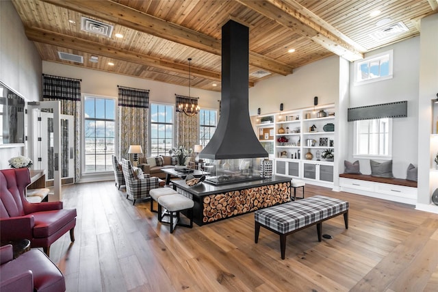 15270 Catalpa Rd, Frisco, TX 75035 - living area featuring wood ceiling with exposed beams, plenty of natural light, hardwood / wood-style flooring, and a wood stove