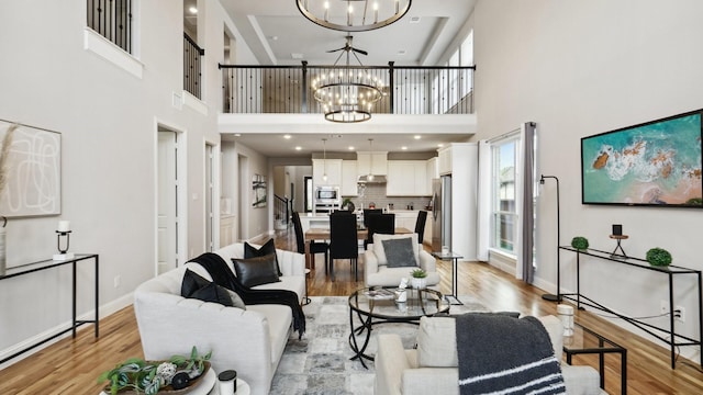 15270 Catalpa Rd, Frisco, TX 75035 - living area featuring a chandelier, light wood-type flooring, a towering ceiling, and baseboards