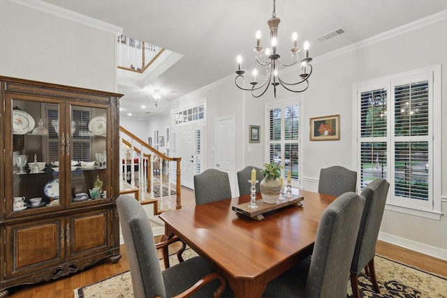 3833 Montecito Dr, Denton, TX 76205 - dining area with light wood finished floors, ornamental molding, a chandelier, baseboards, and stairway