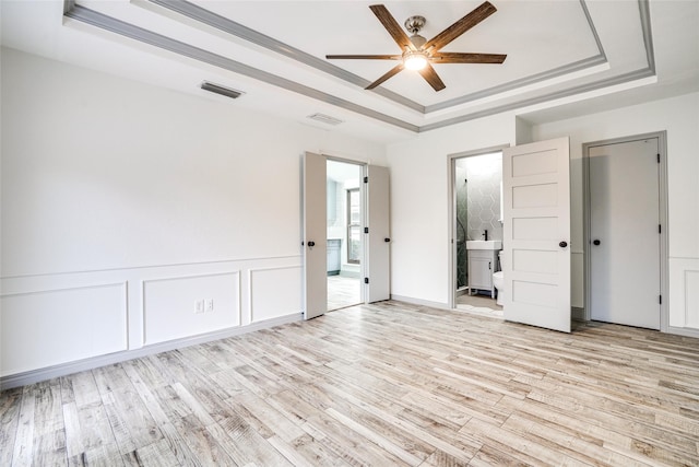 1705 Danube Ln, Plano, TX 75075 - unfurnished bedroom with a tray ceiling, light wood-style floors, ensuite bath, and a ceiling fan