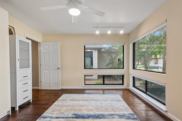 3330 Creekbend Dr, Garland, TX 75044 - unfurnished room featuring dark wood-style flooring, rail lighting, ceiling fan, and baseboards