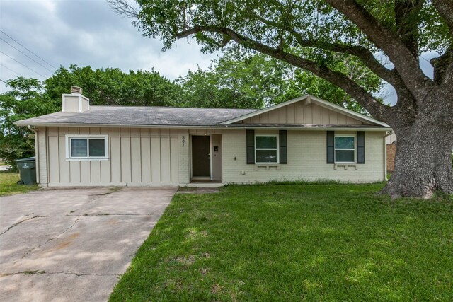 801 Northshore Dr, Garland, TX 75040 - ranch-style house with board and batten siding, a chimney, a front lawn, concrete driveway, and brick siding