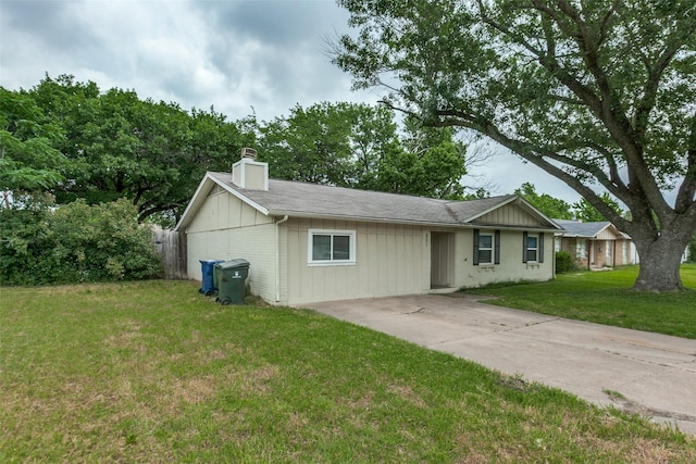 801 Northshore Dr, Garland, TX 75040 - ranch-style home with a chimney, concrete driveway, a front yard, brick siding, and board and batten siding