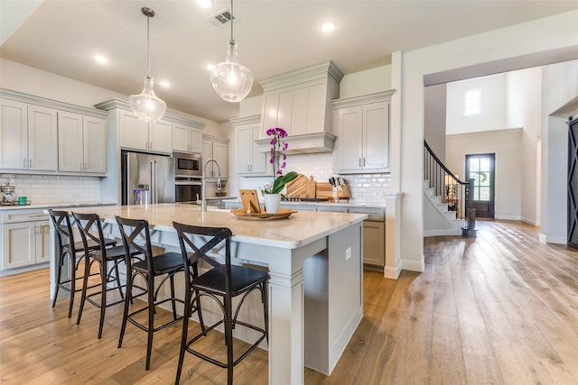 3109 Twin Eagles Dr, Celina, TX 75009 - kitchen with stainless steel appliances, a kitchen bar, a spacious island, tasteful backsplash, and recessed lighting