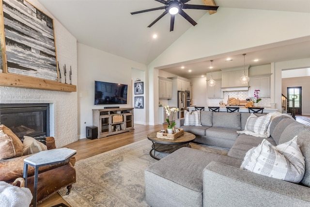 3109 Twin Eagles Dr, Celina, TX 75009 - living room with a ceiling fan, light wood-style flooring, high vaulted ceiling, a fireplace, and recessed lighting
