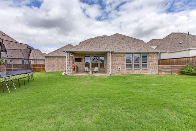 3109 Twin Eagles Dr, Celina, TX 75009 - rear view of property with a trampoline, a patio area, brick siding, and a shingled roof