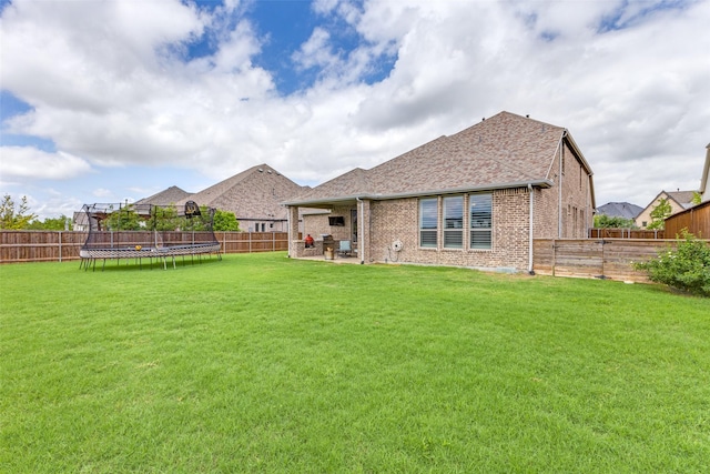 3109 Twin Eagles Dr, Celina, TX 75009 - back of house with a trampoline, brick siding, a patio area, and a shingled roof