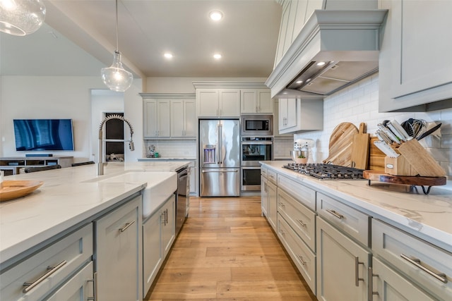 3109 Twin Eagles Dr, Celina, TX 75009 - kitchen with stainless steel appliances, custom exhaust hood, a sink, gray cabinetry, and decorative backsplash