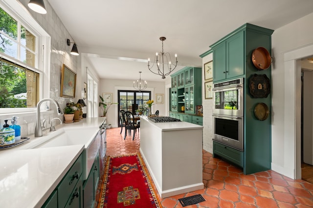 2307 5th Ave, Fort Worth, TX 76110 - kitchen featuring green cabinets, stainless steel double oven, a chandelier, and a kitchen island