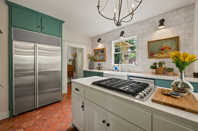 2307 5th Ave, Fort Worth, TX 76110 - kitchen with stainless steel appliances, light countertops, a sink, decorative backsplash, and a chandelier