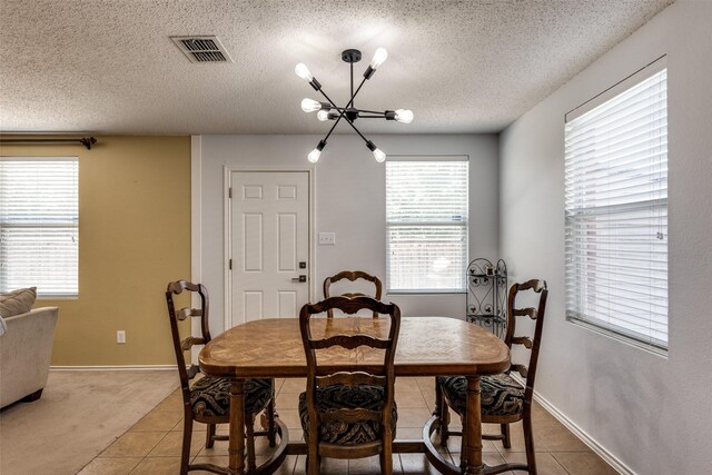 5504 Cedar Mountain Dr, Mckinney, TX 75071 - dining area with a chandelier, a textured ceiling, healthy amount of natural light, light tile patterned flooring, and baseboards
