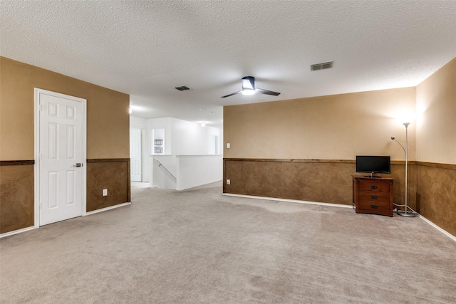 5504 Cedar Mountain Dr, Mckinney, TX 75071 - spare room featuring a wainscoted wall, carpet, a ceiling fan, and a textured ceiling