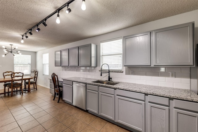 5504 Cedar Mountain Dr, Mckinney, TX 75071 - kitchen with stainless steel dishwasher, gray cabinetry, a sink, track lighting, and a textured ceiling
