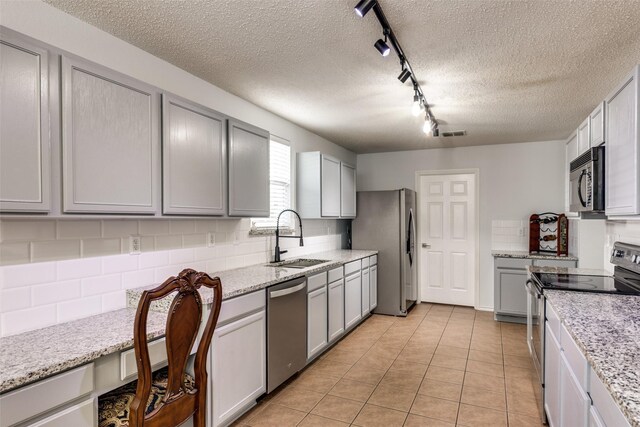 5504 Cedar Mountain Dr, Mckinney, TX 75071 - kitchen featuring appliances with stainless steel finishes, a sink, rail lighting, gray cabinets, and a textured ceiling