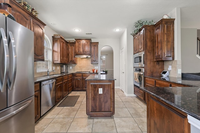 12428 Leaflet Dr, Fort Worth, TX 76244 - kitchen featuring stainless steel appliances, arched walkways, backsplash, dark stone counters, and recessed lighting