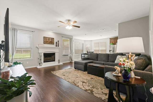 12428 Leaflet Dr, Fort Worth, TX 76244 - living area with ceiling fan, dark wood finished floors, a fireplace with raised hearth, and baseboards