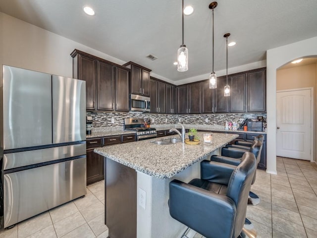 1800 Ridge Creek Ln, Aubrey, TX 76227 - kitchen with stainless steel appliances, a sink, tasteful backsplash, dark brown cabinetry, and recessed lighting