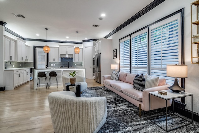 4518 Gilbert Ave, Dallas, TX 75219 - living area featuring crown molding, light wood finished floors, and recessed lighting