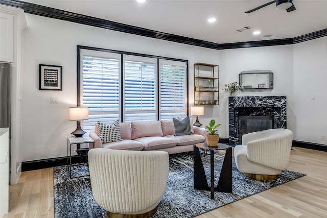 4518 Gilbert Ave, Dallas, TX 75219 - living room featuring crown molding, a premium fireplace, light wood-type flooring, baseboards, and a ceiling fan