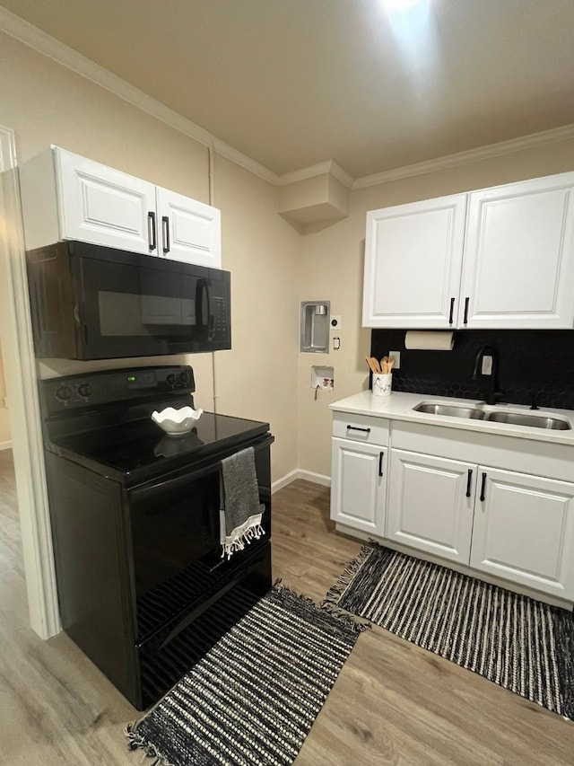 412 Sands Ct, White Settlement, TX 76108 - kitchen featuring black appliances, a sink, crown molding, light wood-type flooring, and white cabinets