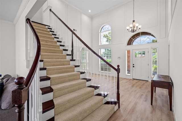 3936 Gillespie Dr, Carrollton, TX 75010 - foyer entrance with stairway, light wood-style floors, a chandelier, crown molding, and a high ceiling