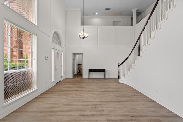 3936 Gillespie Dr, Carrollton, TX 75010 - entrance foyer featuring a chandelier, light wood finished floors, stairs, a towering ceiling, and baseboards