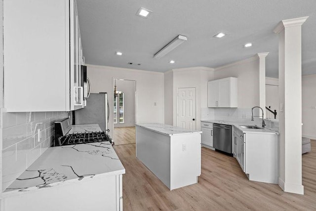 3936 Gillespie Dr, Carrollton, TX 75010 - kitchen featuring stainless steel appliances, a sink, crown molding, a center island, and backsplash