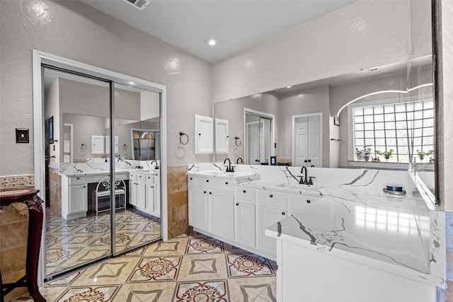3936 Gillespie Dr, Carrollton, TX 75010 - full bath featuring vanity, tile walls, recessed lighting, tile patterned floors, and a textured wall