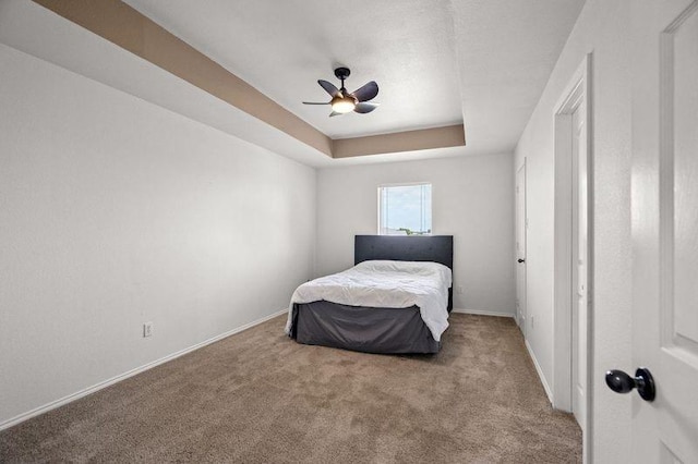3936 Gillespie Dr, Carrollton, TX 75010 - carpeted bedroom featuring baseboards, a raised ceiling, and a ceiling fan