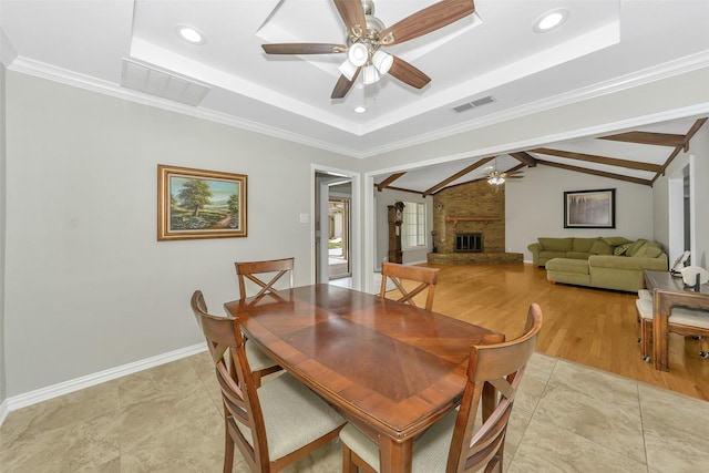 1113 Yorkshire Dr, Carrollton, TX 75007 - dining space with ceiling fan, a fireplace, a raised ceiling, baseboards, and ornamental molding