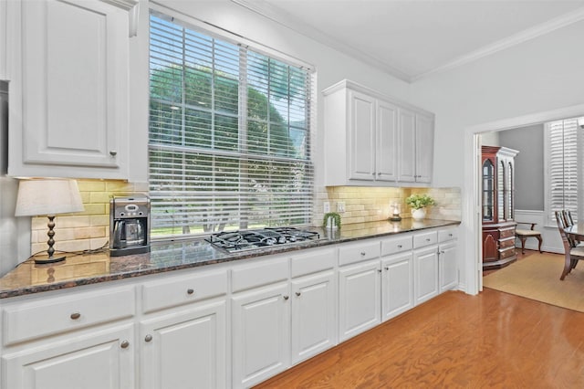 1403 Chelsea Cir, Southlake, TX 76092 - kitchen featuring stainless steel gas stovetop, light wood-style flooring, ornamental molding, white cabinetry, and dark stone countertops