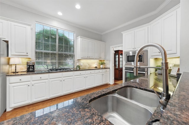 1403 Chelsea Cir, Southlake, TX 76092 - kitchen with stainless steel appliances, white cabinets, wood finished floors, backsplash, and crown molding