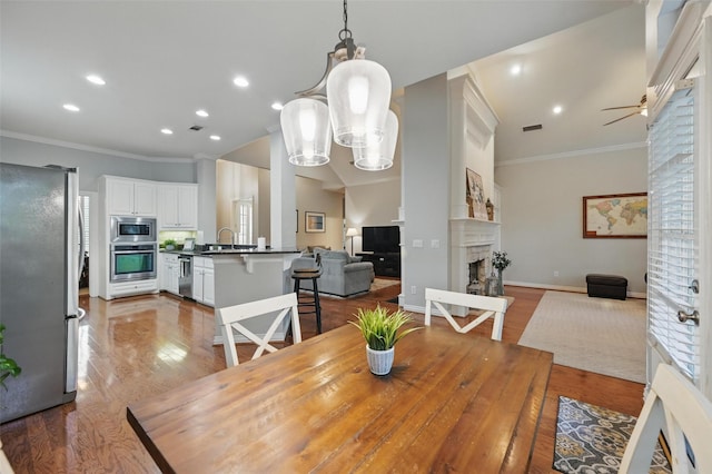 1403 Chelsea Cir, Southlake, TX 76092 - dining area featuring crown molding, a fireplace, wood finished floors, recessed lighting, and a ceiling fan