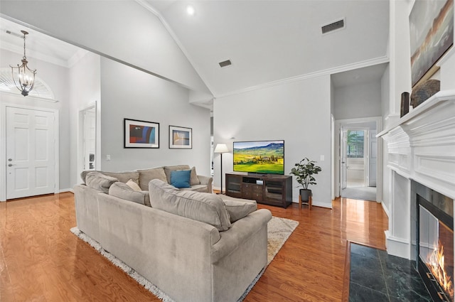 1403 Chelsea Cir, Southlake, TX 76092 - living room with a fireplace with flush hearth, wood finished floors, a chandelier, high vaulted ceiling, and baseboards