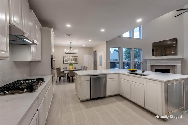 14548 Blakehill Dr, Frisco, TX 75035 - kitchen with stainless steel appliances, under cabinet range hood, a sink, light countertops, and a chandelier
