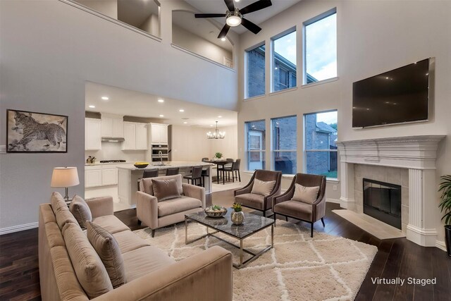 14548 Blakehill Dr, Frisco, TX 75035 - living area featuring wood-type flooring, baseboards, a ceiling fan, a chandelier, and a high ceiling