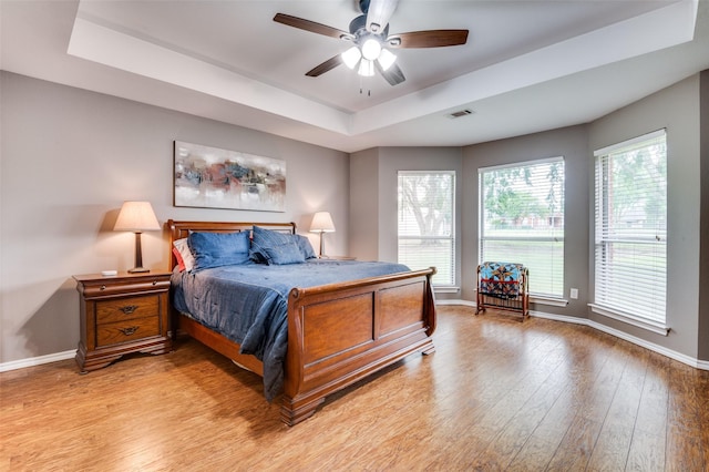 4811 Jakes Way, Midlothian, TX 76065 - bedroom with baseboards, light wood-style flooring, and a raised ceiling