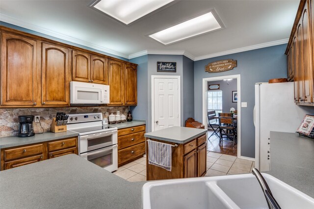 4811 Jakes Way, Midlothian, TX 76065 - kitchen featuring white appliances, a kitchen island, light tile patterned flooring, backsplash, and crown molding