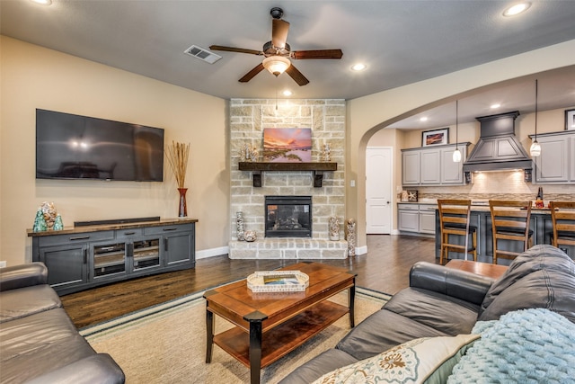 5014 Toledo Bend Dr, Frisco, TX 75033 - living area featuring a ceiling fan, arched walkways, dark wood-style flooring, recessed lighting, and a fireplace