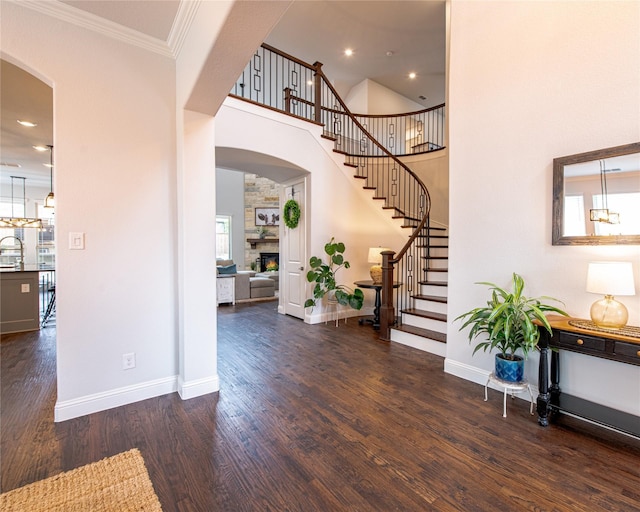 2624 Seabiscuit Rd, Celina, TX 75009 - entrance foyer with stairway, wood finished floors, arched walkways, a warm lit fireplace, and baseboards