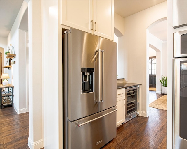 2624 Seabiscuit Rd, Celina, TX 75009 - kitchen featuring high end refrigerator, wine cooler, arched walkways, and dark wood-type flooring
